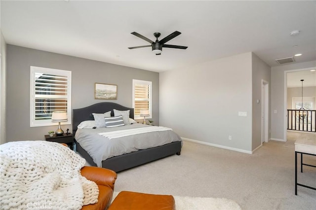 bedroom with multiple windows, ceiling fan, and light carpet