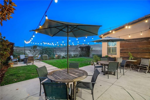 patio terrace at dusk with a lawn and a mountain view