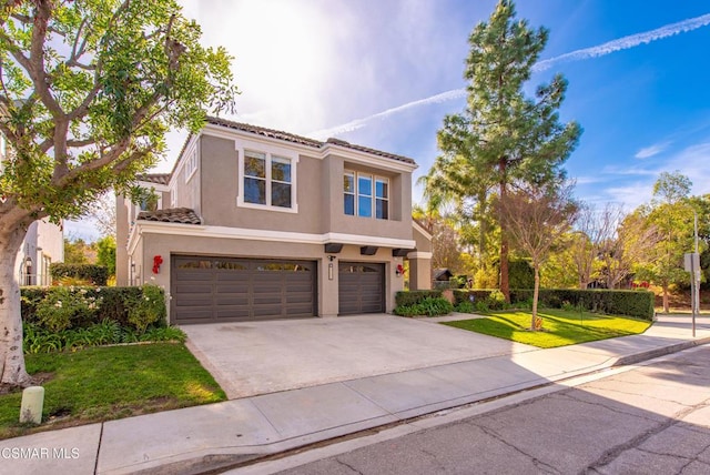 mediterranean / spanish home featuring a garage and a front yard