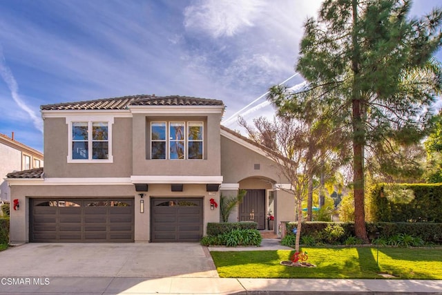 mediterranean / spanish-style house featuring a garage and a front yard