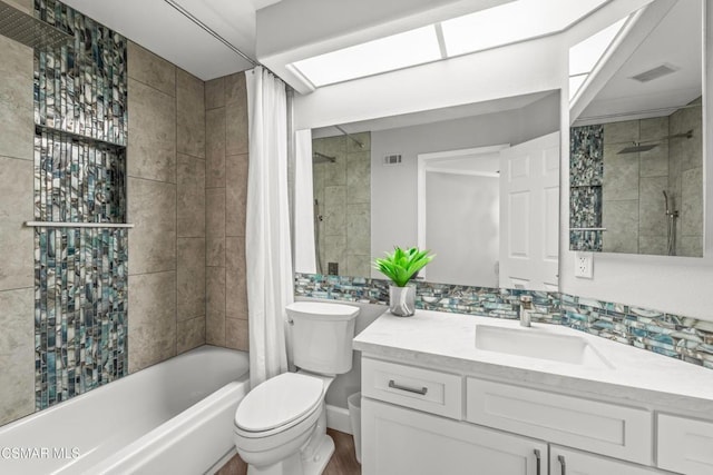 full bathroom with shower / tub combo with curtain, vanity, and toilet