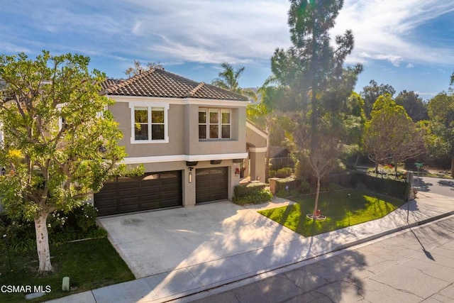 mediterranean / spanish house with a garage and a front lawn