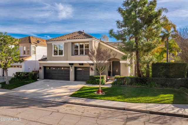 mediterranean / spanish-style home featuring a garage and a front yard