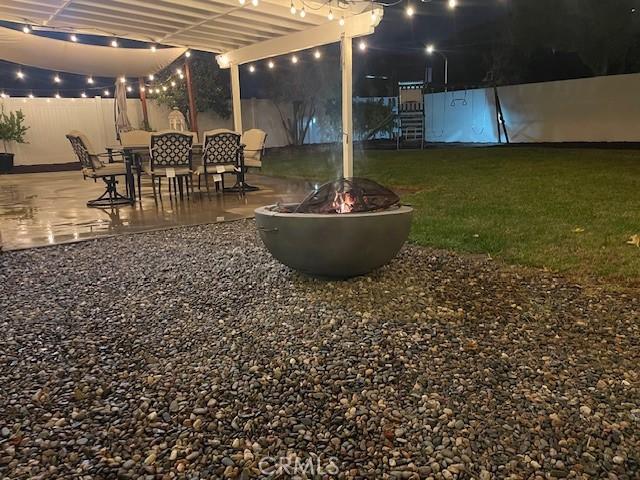 yard at night featuring a patio and an outdoor fire pit