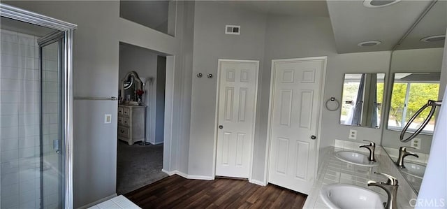 bathroom featuring vanity, hardwood / wood-style flooring, vaulted ceiling, and walk in shower