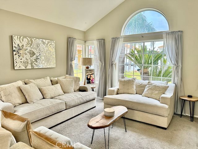 carpeted living room featuring high vaulted ceiling