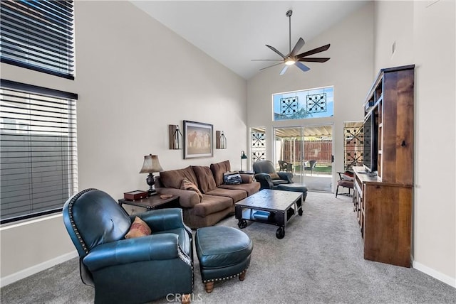 carpeted living room featuring ceiling fan and a towering ceiling