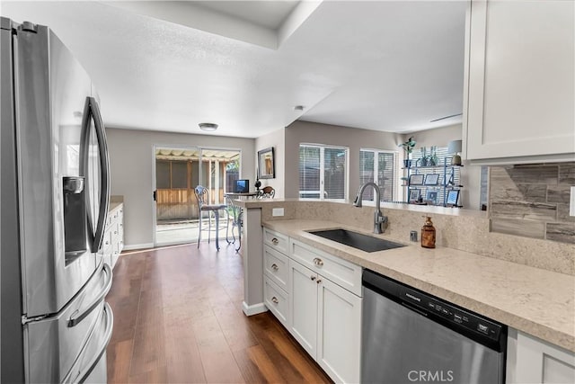 kitchen featuring backsplash, sink, white cabinetry, and appliances with stainless steel finishes