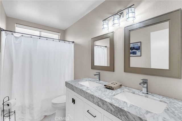 bathroom with toilet, vanity, and walk in shower