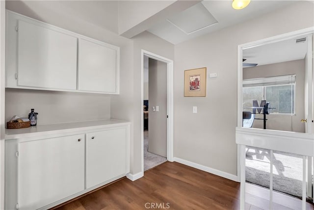 interior space featuring dark hardwood / wood-style flooring and white cabinets