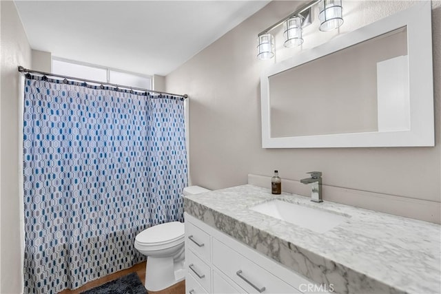 bathroom with toilet, vanity, and curtained shower