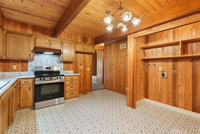 kitchen with wooden walls, stainless steel stove, wood ceiling, and custom exhaust hood