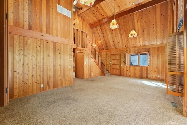 unfurnished living room with carpet flooring, wooden walls, and wooden ceiling