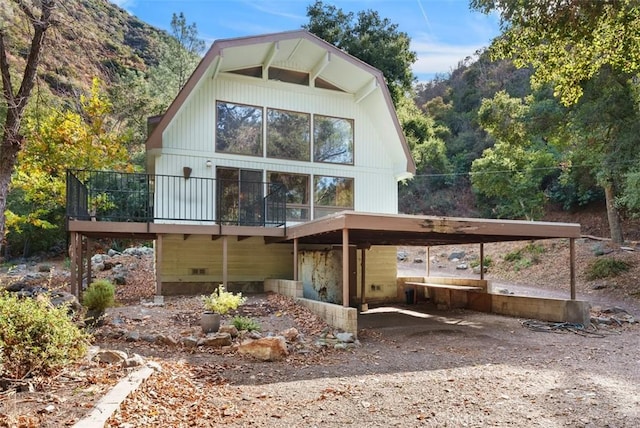 back of house with a wooden deck and a carport