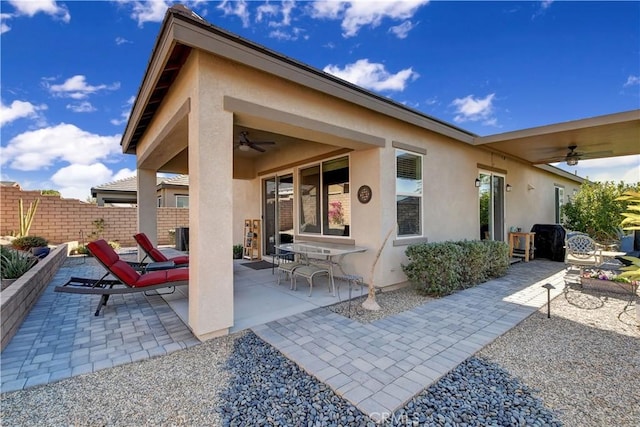 rear view of property featuring ceiling fan and a patio