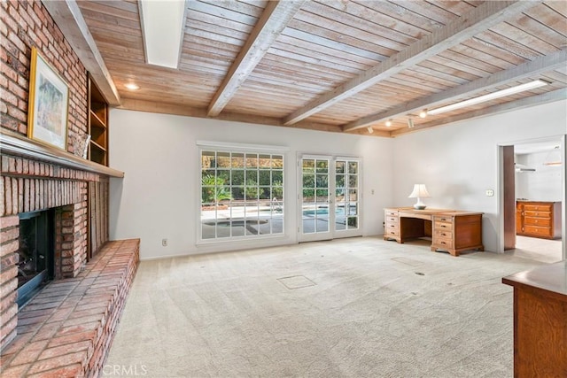 unfurnished living room featuring a fireplace, beam ceiling, wood ceiling, and light carpet