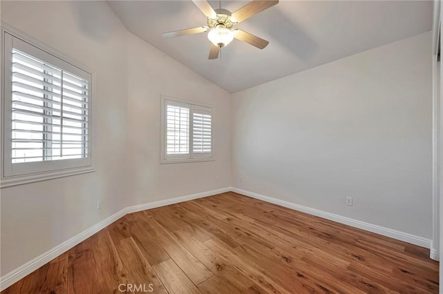 empty room with ceiling fan, lofted ceiling, and hardwood / wood-style flooring