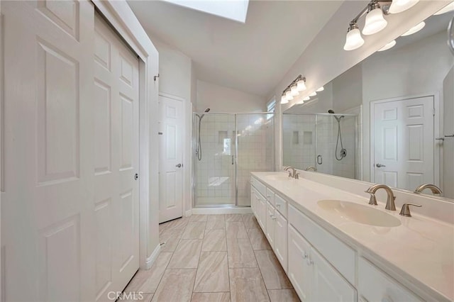 bathroom with lofted ceiling with skylight, a shower with door, and vanity