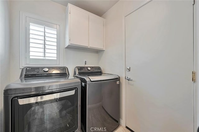 laundry room featuring washer and dryer and cabinets