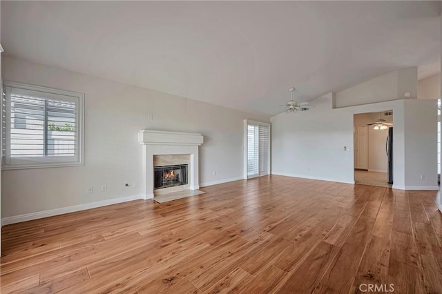 unfurnished living room with ceiling fan, light hardwood / wood-style floors, and vaulted ceiling