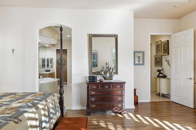 bedroom featuring connected bathroom and dark hardwood / wood-style floors