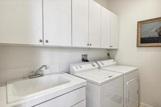 laundry area with cabinets, independent washer and dryer, and sink