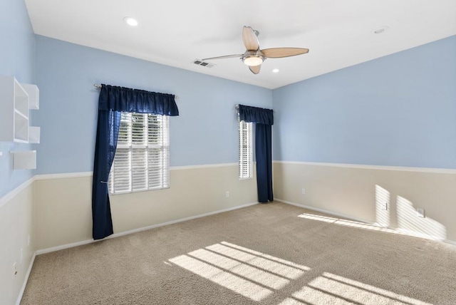 carpeted spare room featuring ceiling fan