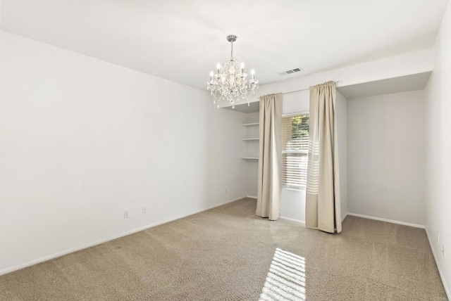 empty room featuring light colored carpet and a notable chandelier