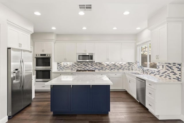 kitchen featuring sink, stainless steel appliances, a kitchen island, dark hardwood / wood-style flooring, and white cabinets