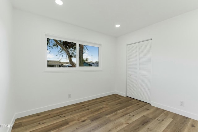 unfurnished bedroom featuring a closet and hardwood / wood-style flooring