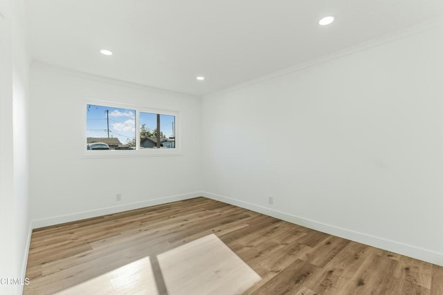 unfurnished room with crown molding and light hardwood / wood-style flooring