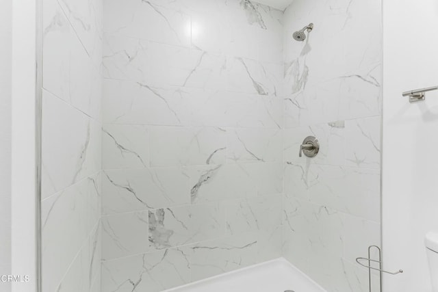 bathroom featuring toilet and tiled shower