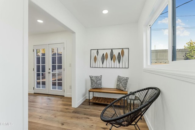 sitting room with french doors, a healthy amount of sunlight, and hardwood / wood-style floors