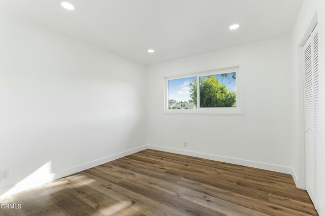 unfurnished bedroom featuring a closet and dark wood-type flooring