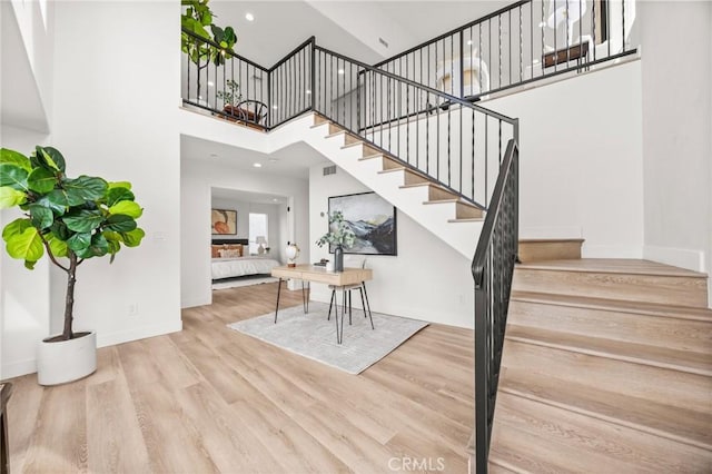 stairway featuring hardwood / wood-style floors and a towering ceiling