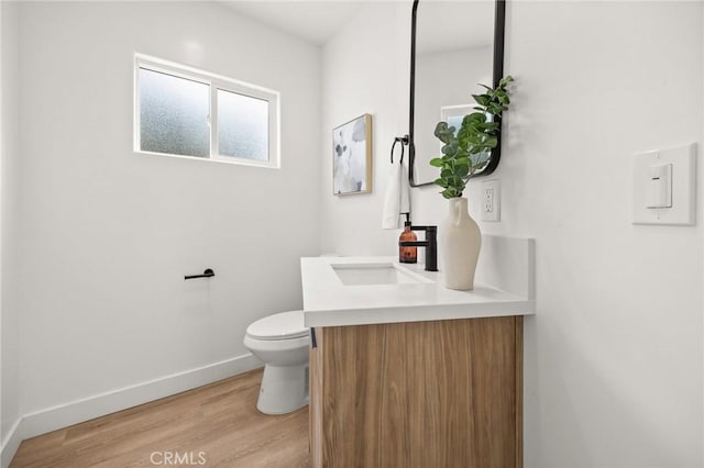 bathroom with hardwood / wood-style floors, vanity, and toilet