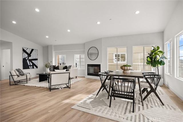 dining area featuring vaulted ceiling and light hardwood / wood-style flooring