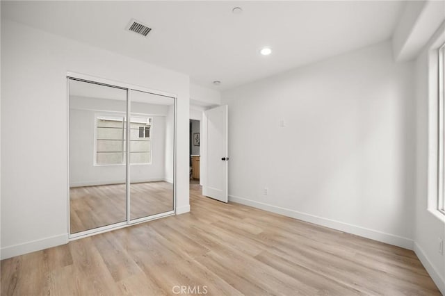 unfurnished bedroom featuring light wood-type flooring and a closet