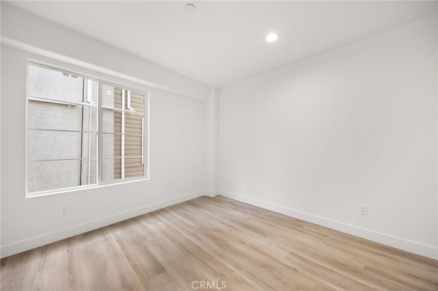 unfurnished room featuring light wood-type flooring and a healthy amount of sunlight