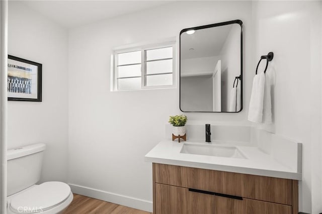 bathroom with vanity, hardwood / wood-style flooring, and toilet