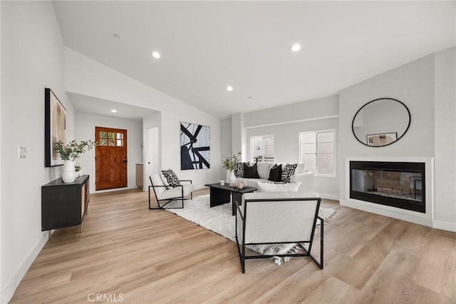 living room with vaulted ceiling and light wood-type flooring