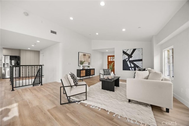 living room with high vaulted ceiling and light hardwood / wood-style flooring