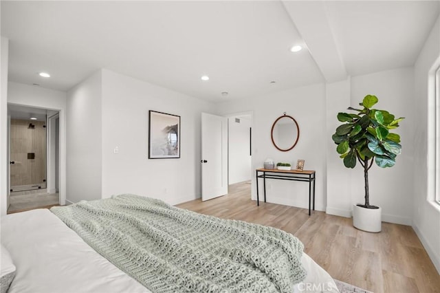 bedroom featuring ensuite bath and light hardwood / wood-style flooring