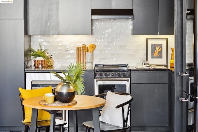 kitchen featuring decorative backsplash, extractor fan, gray cabinets, and stainless steel range with gas stovetop