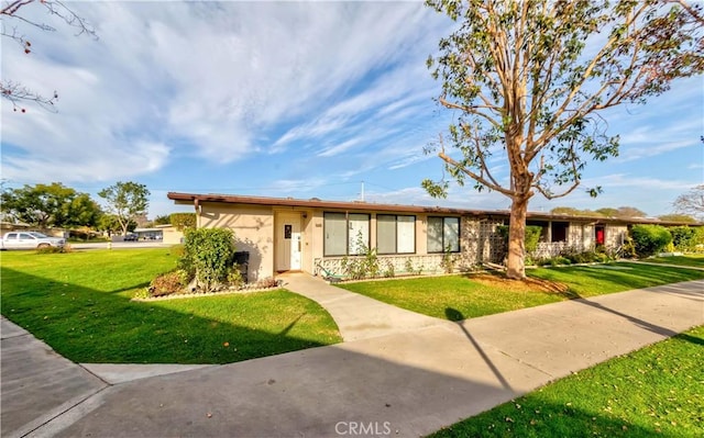 ranch-style home with a front lawn