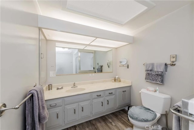 bathroom featuring toilet, vanity, and hardwood / wood-style flooring