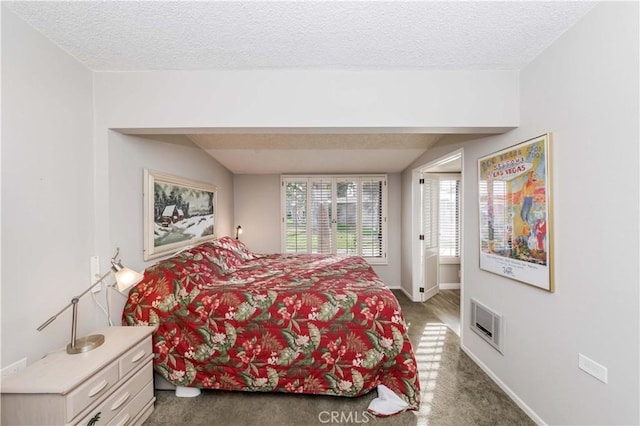 bedroom featuring dark colored carpet and a textured ceiling