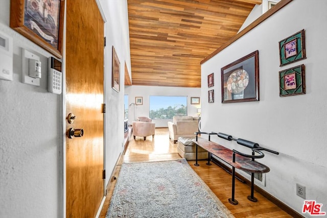 hall with light hardwood / wood-style flooring, wood ceiling, and vaulted ceiling