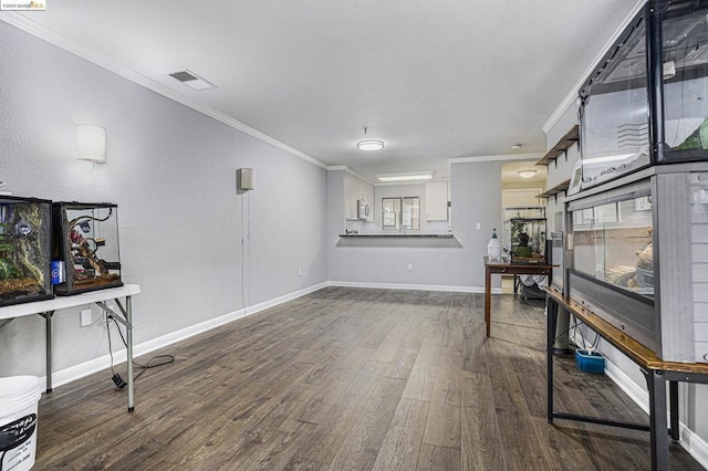 interior space with dark hardwood / wood-style floors and crown molding