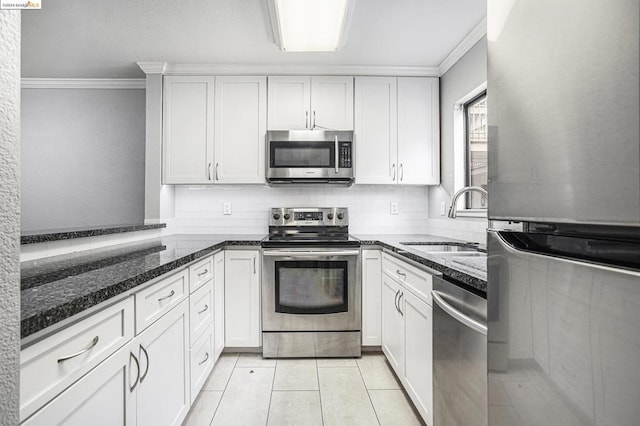 kitchen with white cabinets, dark stone counters, sink, and stainless steel appliances